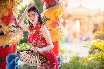 肖像美丽的微笑亚洲年轻的女人穿红色的传统的<strong>中国</strong>人旗袍装饰和持有<strong>中国</strong>人范宁为<strong>中国</strong>人新一年节日<strong>中国</strong>人神社泰国