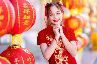 肖像美丽的微笑小可爱的亚洲女孩穿红色的传统的中国人旗袍红色的纸灯笼装饰为中国人新一年节日中国人神社
