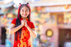 肖像美丽的微笑可爱的小亚洲女孩穿红色的传统的中国人旗袍装饰为中国人新一年节日中国人神社