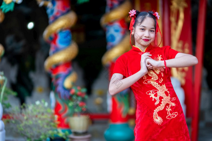 肖像美丽的微笑可爱的小亚洲女孩穿红色的传统的中国人旗袍装饰为中国人新一年节日中国人神社