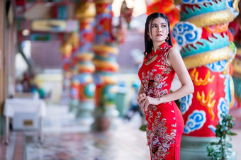 肖像美丽的微笑亚洲年轻的女人穿红色的传统的中国人旗袍装饰为中国人新一年节日中国人神社泰国