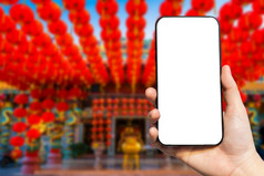 特写镜头女使用智能手机模糊图片美丽的中国人红色的灯笼装饰为中国人新一年节日中国人神社