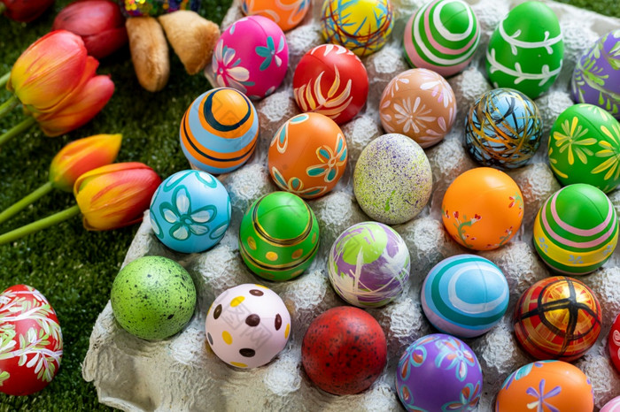 复活节假期概念色彩斑斓的复活节鸡蛋蛋盒子篮子复活节鸡蛋糖果篮子兔子娃娃绿色草背景与空间