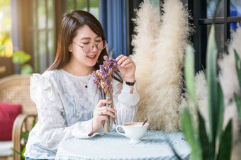 肖像快乐有吸引力的亚洲人可爱的女人闻紫色的花花束薰衣草与<strong>咖啡</strong>杯感觉就像放松<strong>咖啡</strong>商店就像的背景