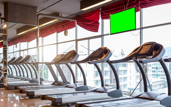 摘要模糊散焦跑步机和监控领导与空绿色白色屏幕体育运动健身房室内和健身健康俱乐部与体育锻炼设备和锻炼有氧运动锻炼