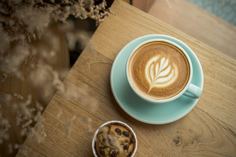 热咖啡拿铁与拿铁艺术牛奶泡沫杯杯子和自制的香蕉杯蛋糕木<strong>桌子</strong>上前视图<strong>早餐</strong>咖啡商店的咖啡馆在业务工作概念