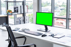 工作空间业务模型桌面电脑空绿色屏幕与键盘笔记本和其他配件现代黑暗木办公室角落里和黑色的办公室椅子与窗口办公室室内