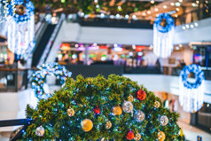 快乐x-mas关闭色彩斑斓的球礼物盒子和圣诞节问候图片包裹装饰绿色圣诞节树的购物购物中心背景装饰在圣诞节和新一年