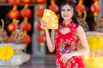 肖像亚洲年轻的女人穿红色的传统的<strong>中国</strong>人旗袍装饰持有黄色的报业信封与的<strong>中国</strong>人文本祝福写<strong>好</strong>运气为快乐<strong>中国</strong>人新一年