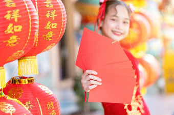 亚洲快乐小女孩穿红色的传统的<strong>中国</strong>人旗袍装饰持有红色的信封手和灯笼与的<strong>中国</strong>人文本祝福写《财富》杂志祝福为<strong>中国</strong>人