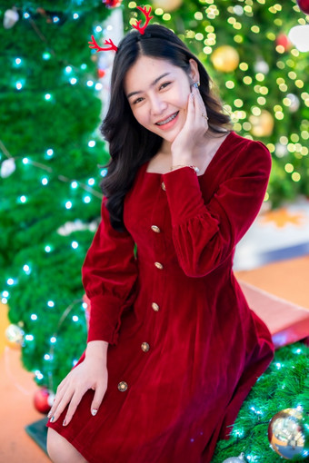 肖像美丽的年轻的亚洲女人红色的衣服服装和圣诞节问候图片包裹装饰圣诞节树光圆形散景背景装饰在圣诞节和新一年