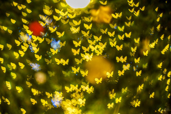 快乐x-mas黄色的色彩斑斓的光摘要蝴蝶散景的光隧道圣诞节树背景装饰在圣诞节和爱新一<strong>年节</strong>日照明