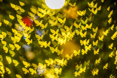 快乐x-mas黄色的色彩斑斓的光摘要蝴蝶散景的光隧道圣诞节树背景装饰在圣诞节和爱新一年节日照明
