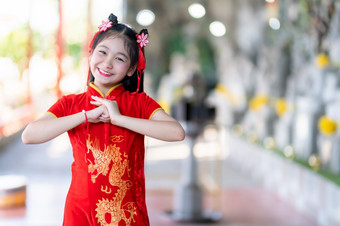 肖像微笑可爱的小亚洲女孩穿红色的旗袍衣服传统的装饰为中国人新一<strong>年节</strong>日庆祝文化中国中国人神社