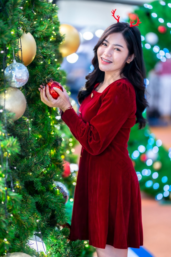 肖像美丽的年轻的亚洲女人红色的衣服服装和圣诞节问候图片包裹装饰圣诞节树光圆形散景背景装饰在圣诞节和新一年
