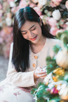 肖像可爱的美丽的积极的微笑年轻的亚洲女人装修圣诞节树首页的生活房间在室内装饰在圣诞节x-mas和新一年假期