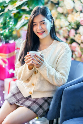 肖像美丽的年轻的亚洲女人持有积极的的有杯咖啡<strong>牛奶</strong>巧克力<strong>首页</strong>的生活房间在室内装饰在圣诞节x-mas和新一年假期