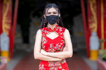 亚洲年轻的女人穿红色的旗袍衣服传统的装饰和穿保护面具细菌为中国人新一年节日神社预防的传播新冠病毒病毒