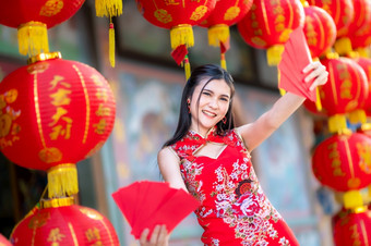 亚洲女人穿红色的<strong>旗袍</strong>衣服<strong>传统</strong>的装饰持有红色的信封手和灯笼与的中国人文本祝福写《财富》杂志祝福为中国人新一年