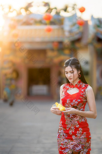 肖像<strong>美丽</strong>的微笑亚洲年轻的女人穿红色的传统的<strong>中国</strong>人旗袍装饰持有金钱袋为<strong>中国</strong>人新一年节日<strong>中国</strong>人神社泰国