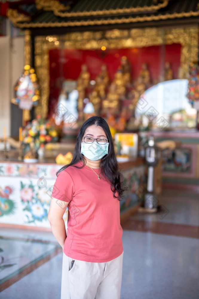 肖像亚洲女人旅行者穿保护面具细菌祈祷中国人佛教寺庙神社泰国预防的传播新冠病毒病毒中国人新一年