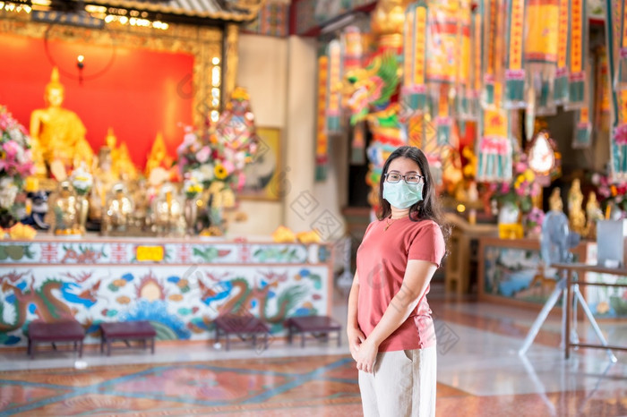 肖像亚洲女人旅行者穿保护面具细菌祈祷中国人佛教寺庙神社泰国预防的传播新冠病毒病毒中国人新一年