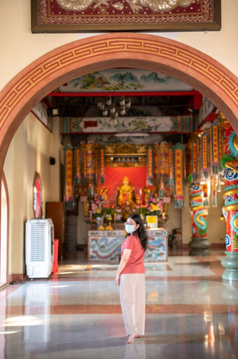 肖像亚洲女人旅行者穿保护面具细菌祈祷中国人佛教寺庙神社泰国预防的传播新冠病毒病毒中国人新一年