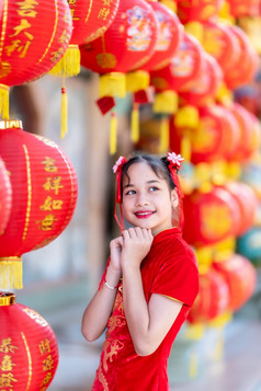 小可爱的亚洲女孩穿传统的中国人旗袍红色的与纸灯笼与的中国人字母祝福写《财富》杂志祝福赞美装饰为中国人新一年