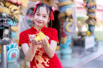 肖像<strong>美丽</strong>的微笑可爱的小亚洲女孩穿红色的传统的<strong>中国</strong>人旗袍装饰焦点显示金钱袋为<strong>中国</strong>人新一年节日<strong>中国</strong>人神社泰国