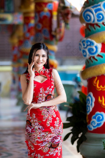 肖像美丽的微笑亚洲年轻的女人穿红色的<strong>旗袍</strong>衣服传统的装饰为<strong>中国</strong>人新一年节日庆祝文化<strong>中国中国</strong>人神社泰国
