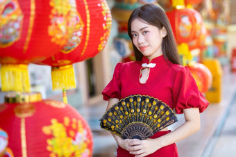 亚洲女人穿红色的传统的<strong>中国</strong>人<strong>旗袍</strong>装饰与纸灯笼与的<strong>中国</strong>人字母祝福写《财富》杂志祝福赞美装饰为<strong>中国</strong>人新一年