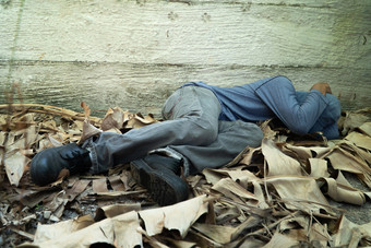 无家可归的人穿灰色的他和灰色的长袖衬衫睡觉因为疲惫与的回来倾斜对的<strong>西门</strong>子墙