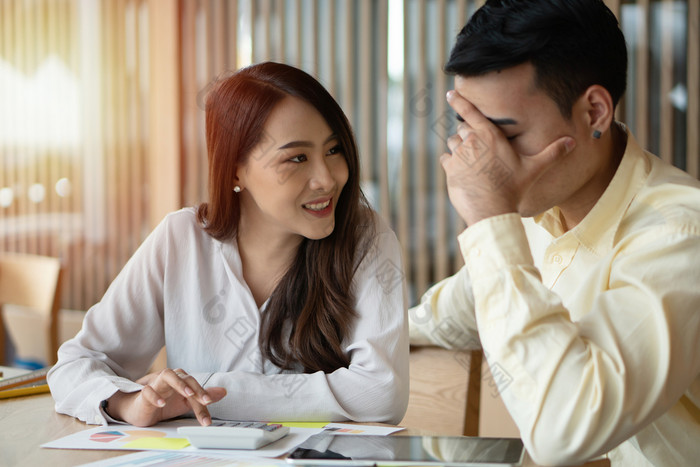 快乐亚洲夫妻微笑后计算收入和费用因为接收利润从投资概念为投资规划和金融规划为的家庭