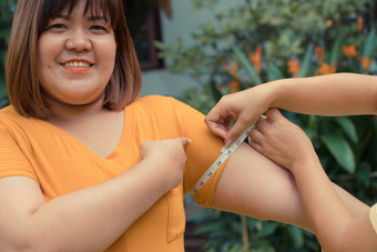 超重女人的公园和测量的比例的上手臂她司马林因为她失去了重量和可以成比例的下来概念重量损失努力