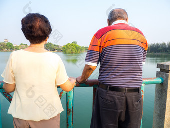 快乐浪漫的高级亚洲夫妇站的桥前面的湖丈夫站与他的妻子概念高级夫妇和取哪每一个其他