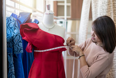 亚洲女人裁缝时尚设计师测量大小人体模型展厅概念女装裁缝和时尚