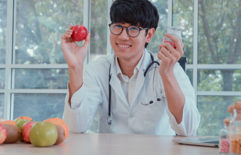 医生营养学家持有苹果和维生素瓶的诊所好健康开始与你有用的食物概念