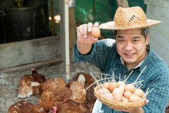 亚洲农民持有鸡蛋篮子与他们的左手和他们的正确的手持有蛋和持有鸡农场他们的自己的首页区域