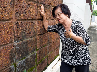 高级女人有胸部疼痛和她的持有乳房因为心梗死心攻击概念