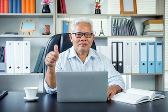 快乐亚洲上了年纪的男人。坐着前面移动PC电脑拇指和微笑的上了年纪的可以仍然工作和创建<strong>句子</strong>为社会病毒检疫