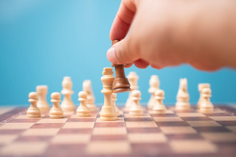 的手商人持有棕色（的）王国际象棋和使彻底失败竞争对手和赢得的游戏概念领导<strong>必须</strong>有业务策略和竞争对手评价竞争