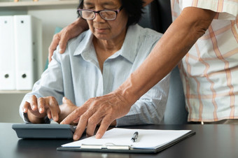 高级亚洲夫妇使用的计算器和文书工作桌子上首页计算费用和收入和储蓄后退休概念金融规划和投资为退休人员