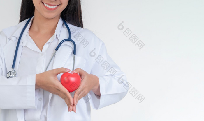 年轻的女医生与听诊器持有心孤立的白色背景概念心脏病学医疗保健和医疗专家医院