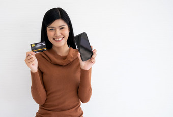 快乐亚洲女人持有卡信贷和智能手机为移动银行的互联网概念新生活方式和融资技术
