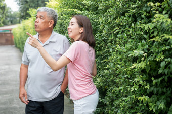 老上了年纪的亚洲男人。和走的后院与她的女儿概念快乐退休与哪从照顾者和储蓄和高级健康保险