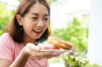 的美丽的亚洲健康的中间岁的女人快乐吃甜甜圈因为有不吃为长时间因为希望为健康概念健康哪和有营养的食物