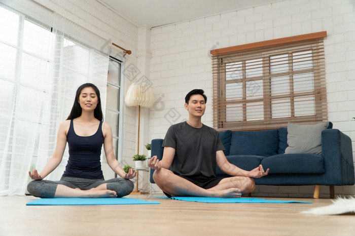 健康的年轻的亚洲夫妇有吸引力的夫妇练习瑜伽练习坐着席莲花构成在线类检疫首页概念技术为新正常的生活方式