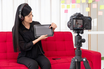 视频博客亚洲女人博主影响者坐着的沙发首页和记录视频博客为教学和教练她的学生订阅者概念的内容创造者在线为新生活方式
