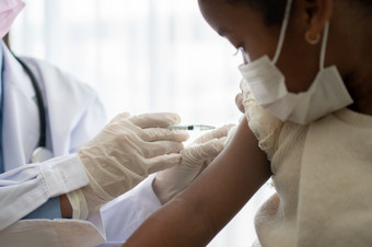 亚洲医生用户注射器针为注射接种疫苗非洲美国孩子们是被科维德接种疫苗为预防冠状病毒和流感概念免疫接种从接种