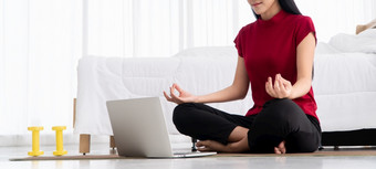 肖像健康的年轻的亚洲女人<strong>练习</strong>瑜伽<strong>练习</strong>坐着的卧室和学习在线移动PC首页概念锻炼和放松技术为新正常的生活方式